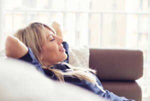 relaxed-woman-leaning-back-on-couch-with-eyes-closed